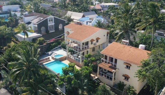 Tropical villa with a large pool, lush gardens, spacious rooms, and privacy.